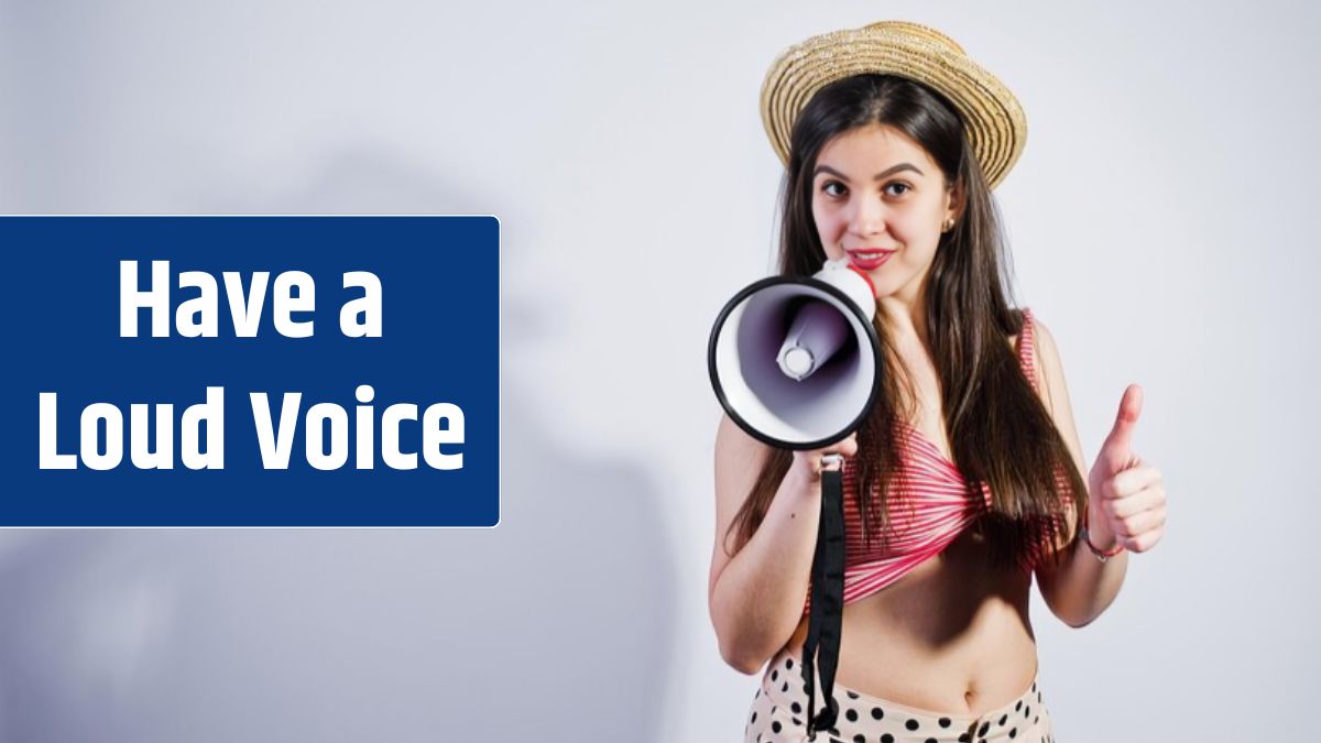 Portrait of a gorgeous young girl in swimming suit and hat talks into megaphone in studio.