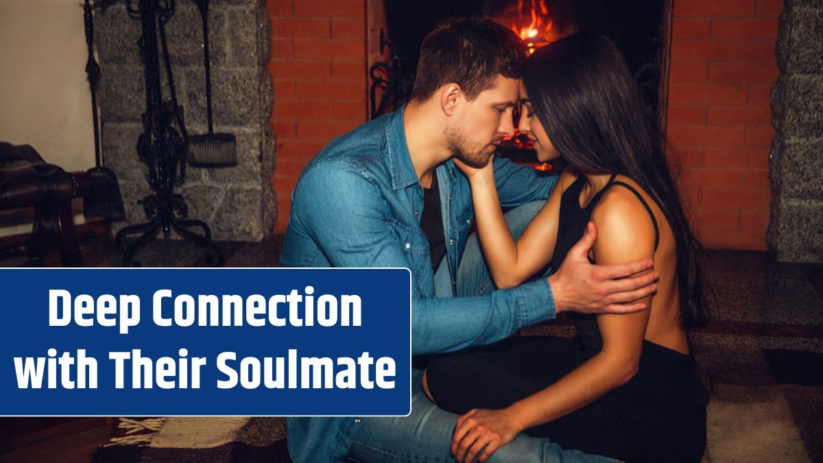 Tender and romantic picture of young couple sitting together at fireplace. They touch their foreheads and look in eyes. Guy hold hand on her forearm.